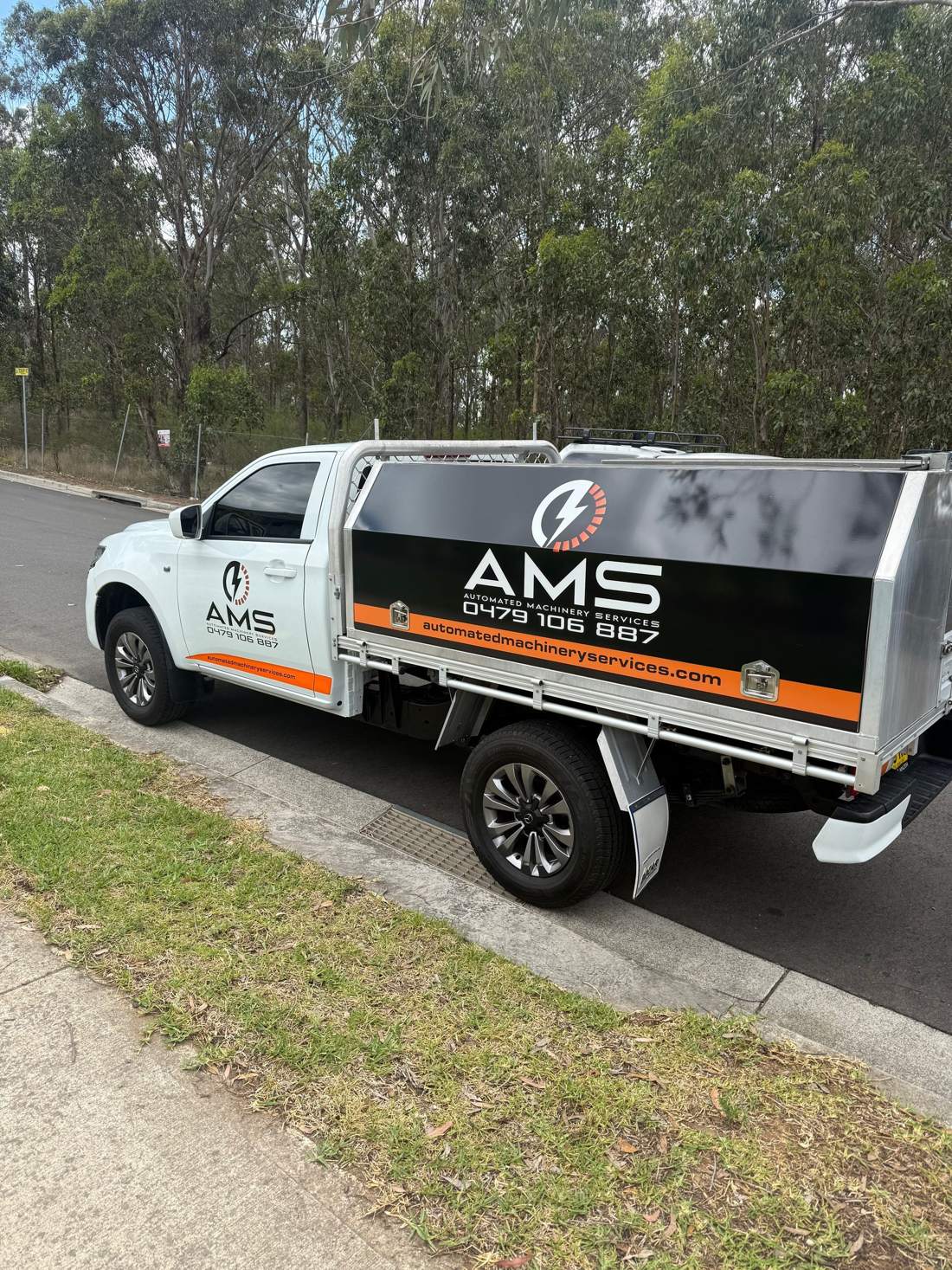 An AMS service ute with its tool canopy, parked at a work site